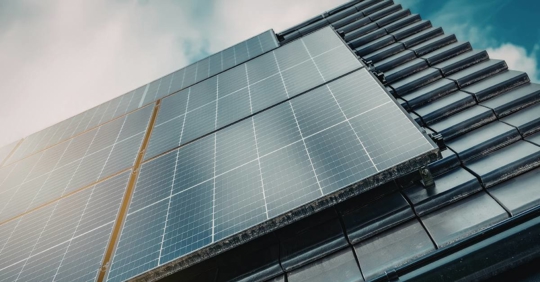 Solar panels on a roof with a blue sky